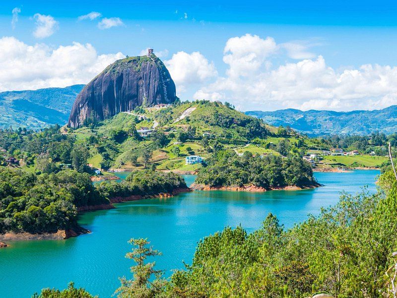 The Piedra del Pe&ntilde;ol standing over the turquoise Guatap&eacute; reservoir